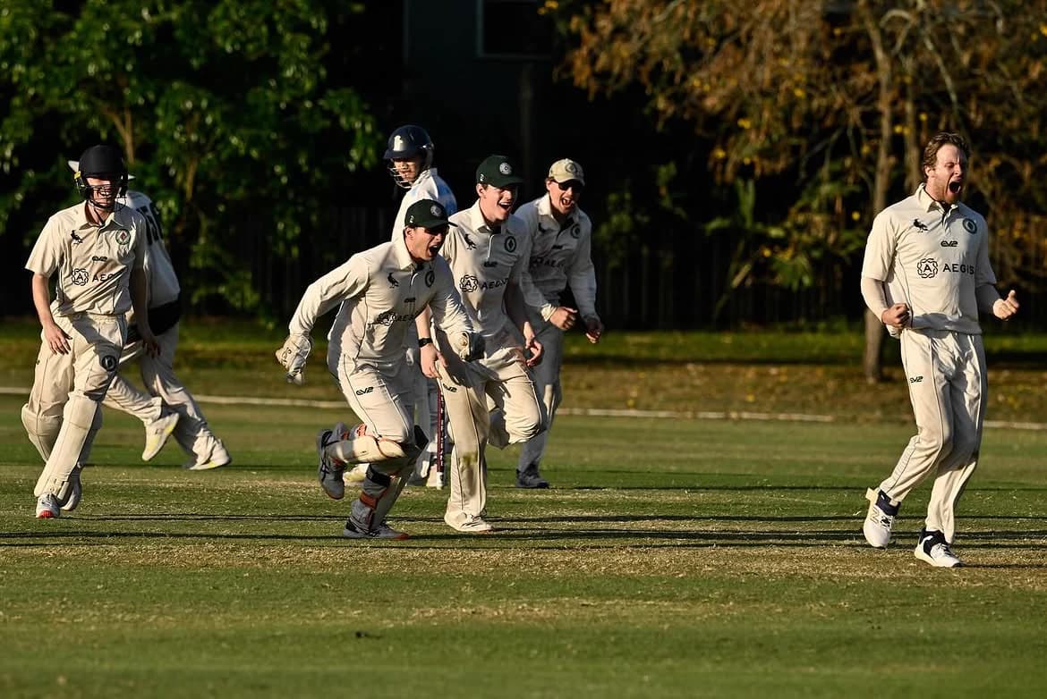 Magpies players celebrating a wicket at Fehlberg Park, dusk